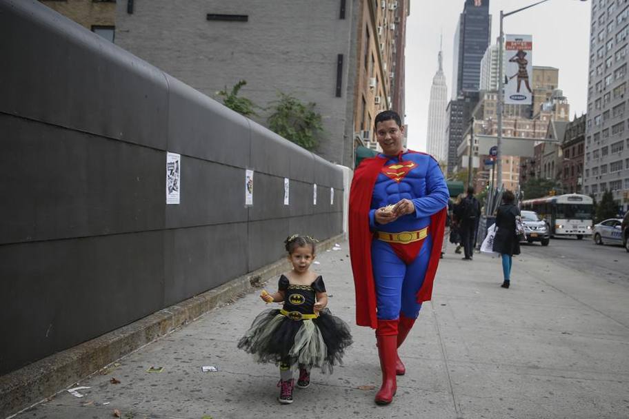 Superman e una baby Batman camminano insieme per le strade di New York